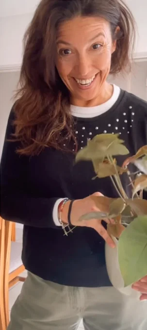 Pau, sonriendo, con una planta en las manos